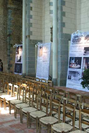 autre vue de la scénographie de l'exposition avec chaises et panneaux